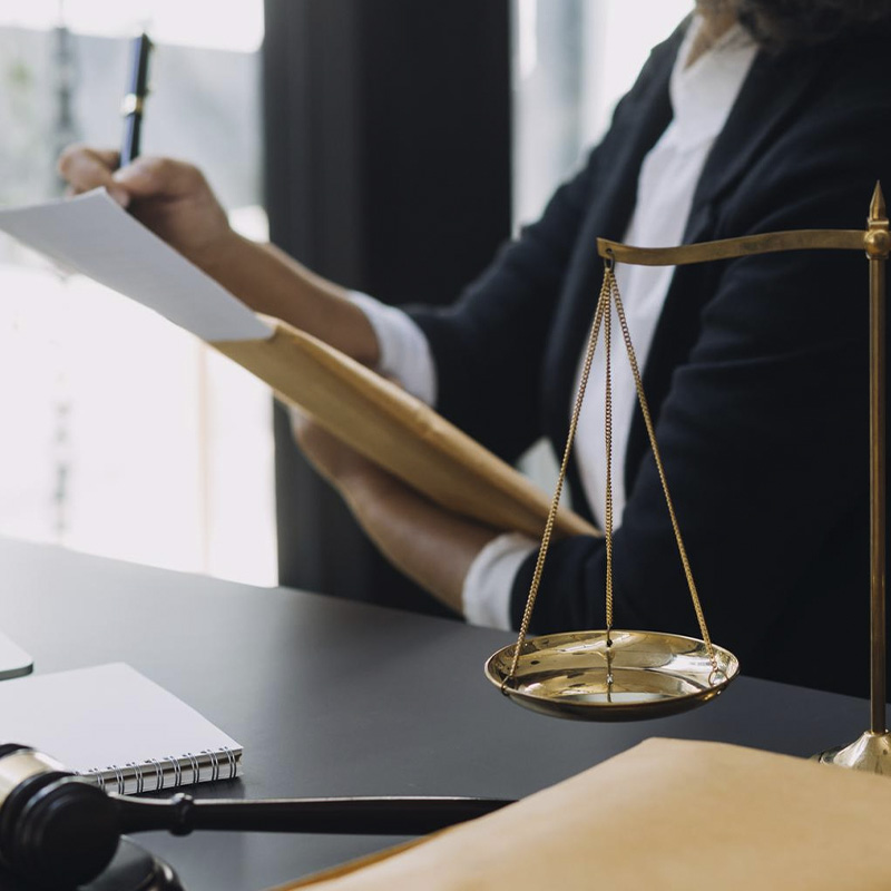 IMAGEM DE MULHER DA JUSTIÇA ANOTANDO UM PROCESSO COM DECORAÇÃO DE BALANA EM PRIEMIRO PLANO
